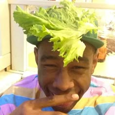 a man with lettuce on his head making a funny face