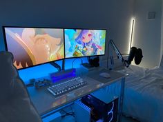 two computer monitors sitting on top of a desk next to a keyboard and monitor screen