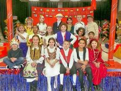 a group of people posing for a photo in front of a stage with blue and red decorations