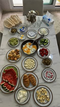 a table topped with plates and bowls filled with food