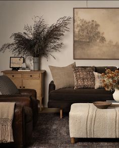 a living room filled with furniture and a large painting on the wall above it's headboard