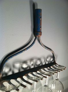 a rack with wine glasses hanging from it's side on the wall next to a white wall