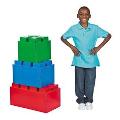 a young boy standing next to colorful boxes and posing for the camera with his hands on his hips