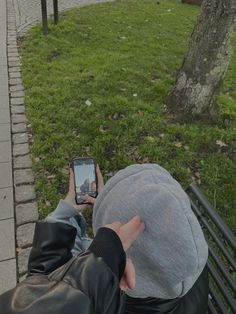 a person sitting on a bench looking at their cell phone