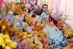 a woman is sitting in front of flowers