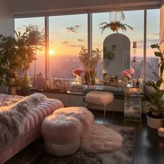 a bedroom with a large window overlooking the city at sunset, and pink furniture in front of it