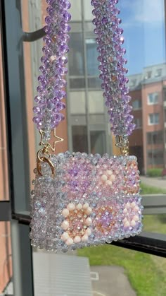 some beads are hanging from a window sill in front of a building with windows