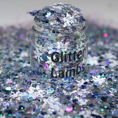 a jar filled with glitter sitting on top of a floor covered in lots of silver and white