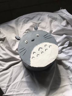 a cake shaped like a totoro sitting on top of a white sheet