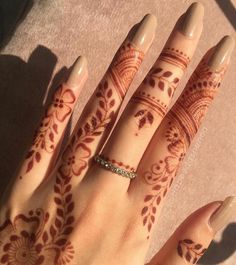 a woman's hand with henna tattoos on it