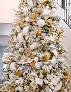 a decorated christmas tree with white and gold ornaments