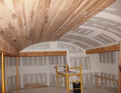 an unfinished room with scaffolding on the ceiling and wood beams in place for insulation