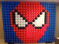 a wall made out of plastic balls with a red, white and blue face on it