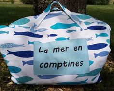 a bag that has been made to look like it is holding a sign with the words la mer en comptines on it