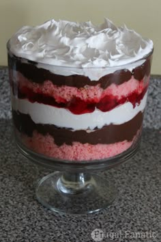 a cake with white frosting and red and black stripes on it sitting on a counter