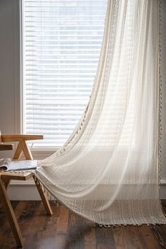 a white sheer curtain hanging in front of a window