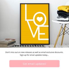 a yellow poster with the words love on it in white and black, next to a chair