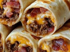 several burritos with meat and cheese are stacked on top of each other, ready to be eaten