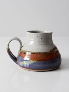 a white and blue vase sitting on top of a table