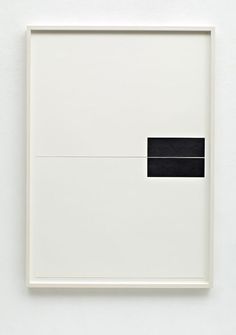 a white square with a black rectangle in the middle on top of it, against a white wall