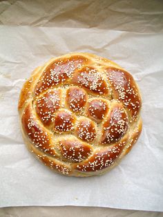 a bread with sesame seeds on it sitting on wax paper