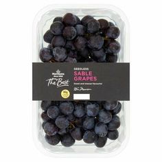 black grapes in a plastic container on a white background, with the label above it