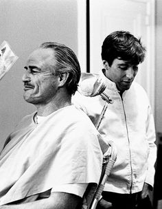 black and white photograph of a man getting his hair cut