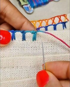 someone is stitching something on the side of a piece of fabric with scissors and thread