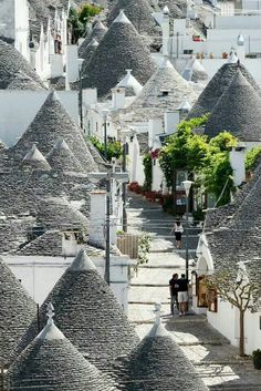 an aerial view of many white buildings with thatched roofs