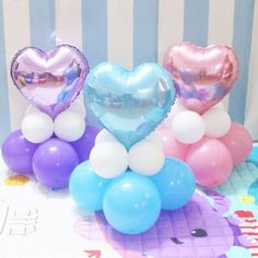 three heart shaped balloons sitting on top of a table