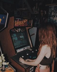 a woman playing a video game in a room with other games on the walls and around her