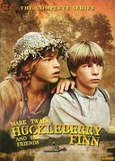 two young boys are standing next to each other in front of a poster for the movie huckleberry finn