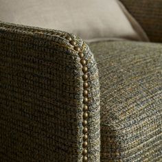 the back end of a couch with buttons on it's armrests and an upholstered cushion