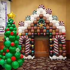 an inflatable christmas tree next to a decorated gingerbread house