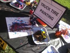 there is a sign that says truck tire painting next to some paintbrushes on the table