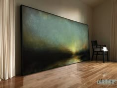 a large painting sitting on top of a hard wood floor next to a white chair