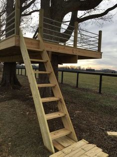 a tree house with stairs leading up to the top