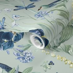 a wallpaper with blue flowers and butterflies on it's side, next to a white vase