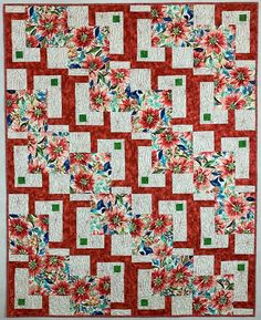 a large red and white quilt with flowers on it's sides, in the center