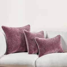 two pillows sitting on top of a white couch