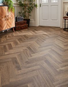 a living room filled with furniture and a wooden floor covered in hard wood planks