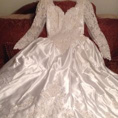 a white wedding dress sitting on top of a couch