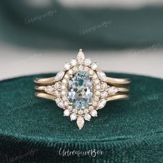 an engagement ring with a blue topazte surrounded by white diamonds on a green velvet box