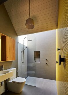 a bathroom with a toilet, sink and shower stall in the middle of it's walls