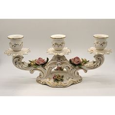 a set of four candlesticks with roses on them