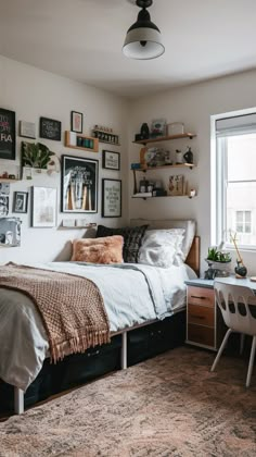 a bed sitting in a bedroom next to a window with pictures on the wall above it