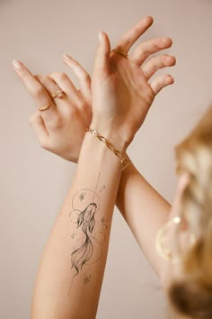 two hands with tattoos on them are reaching up towards each other to reach the viewer's eye