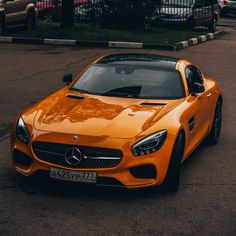 an orange sports car parked on the street