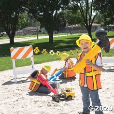 two children are playing in the sand with construction equipment