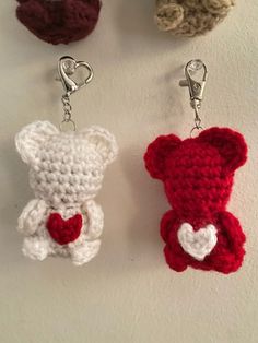 three crocheted keychains with hearts attached to them, hanging on a wall